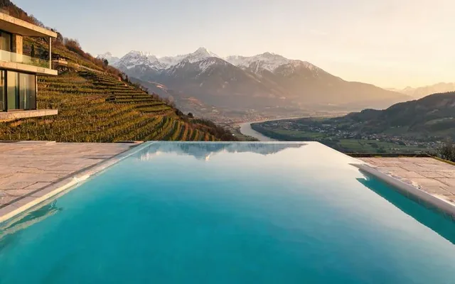 Piscine à débordement sur les hauteurs de Sion avec vue sur la vallée du Rhône et les Alpes